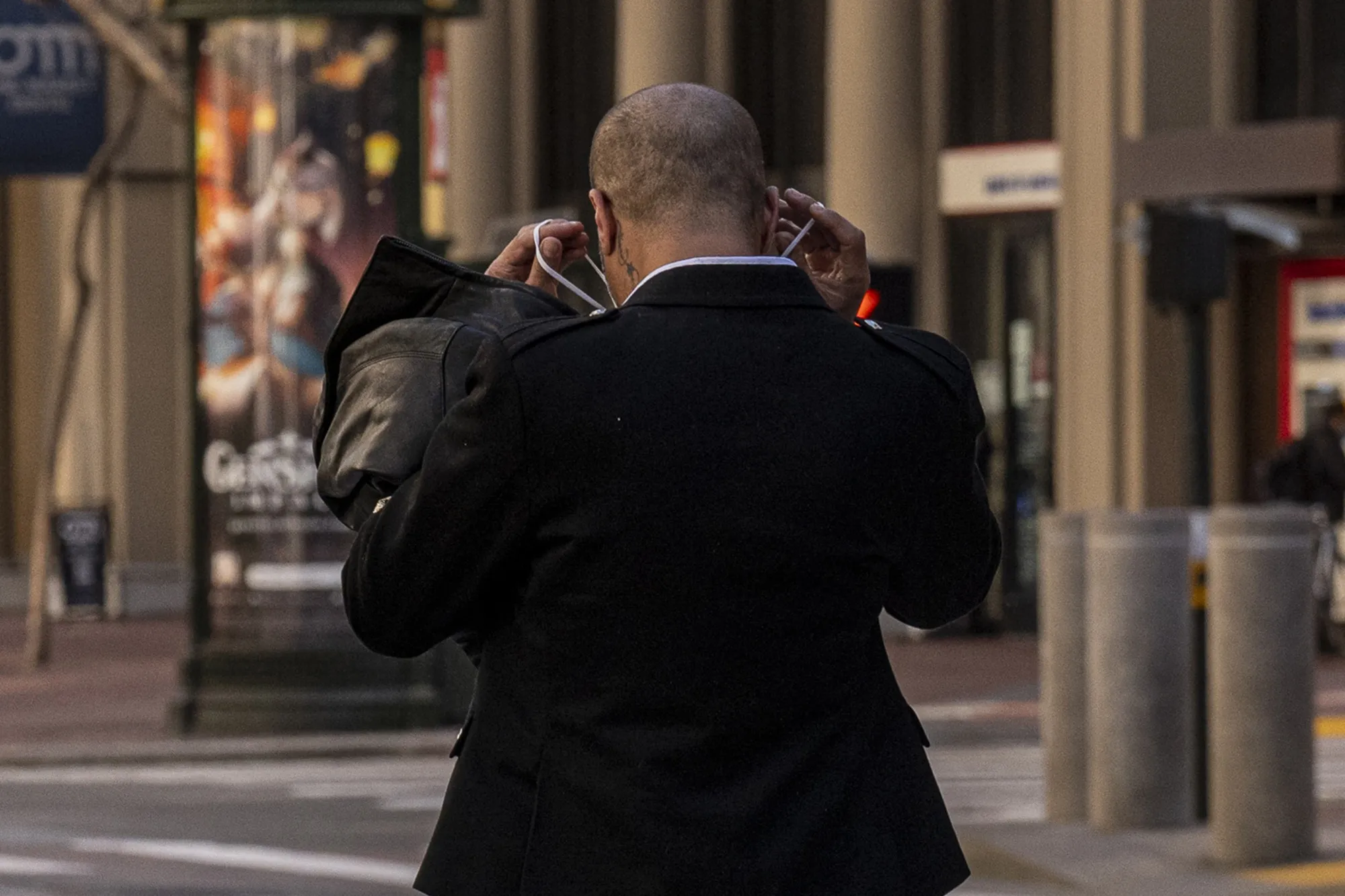 A pedestrian puts on a protective mask on Market Street in San Francisco earlier in February.&nbsp;