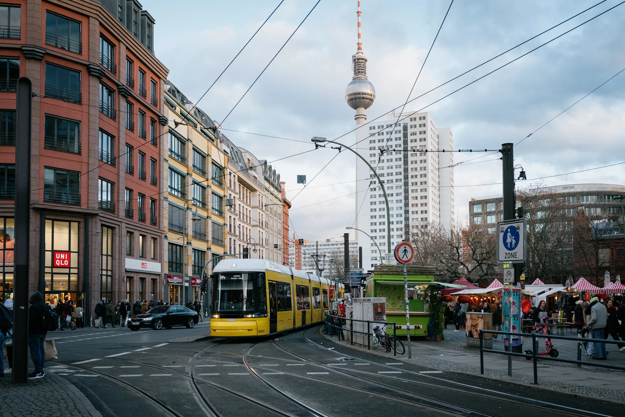 A tram passes shoppers and pedestrians at Hackescher market square in Berlin, Germany.