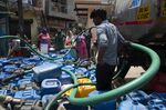 Residents of New Delhi fill containers from a water tanker on May 13.