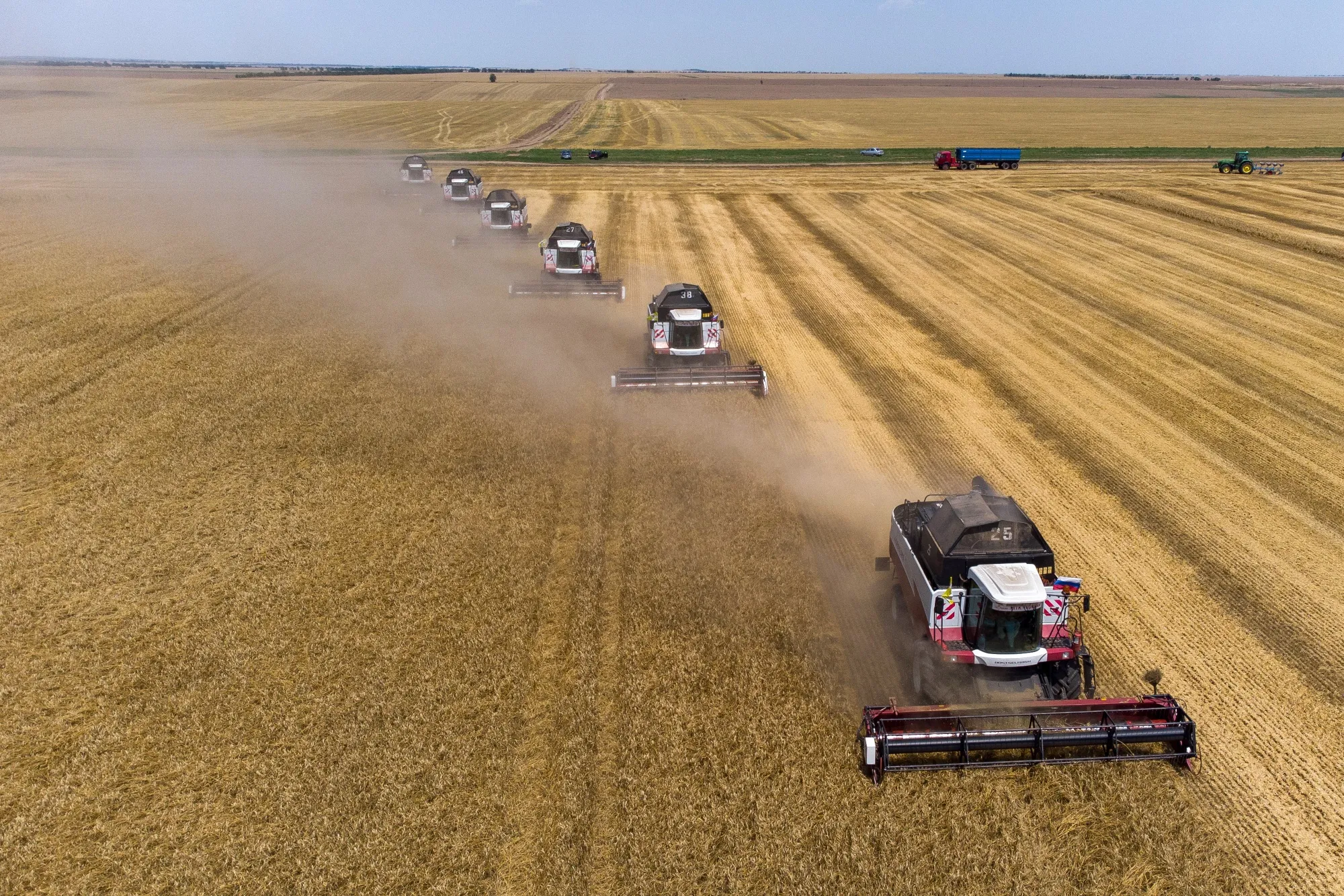 Combine harvesters drive through a wheat field near Stavropol, Russia.