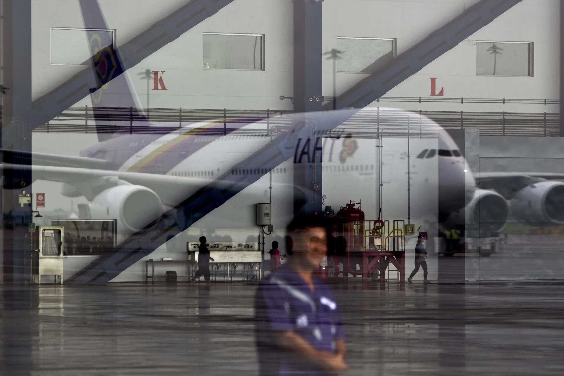 A Thai Airways International Pcl Airbus SAS A380-800 aircraft is reflected in a window at Suvarnabhumi Airport in Bangkok, Thailand, on Saturday, Sept. 29, 2012. Thai Airways received its first Airbus A380 superjumbo, boosting efforts to compete with Singapore Airlines Ltd. and Emirates for lucrative corporate travelers.