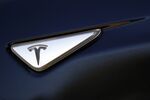 A Tesla logo is displayed on a Tesla Inc. Model S electric vehicle.