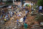 Firefighters and residents search for victims near houses destroyed by a landslide after heavy rains in Franco da Rocha, Sao Paulo state, Brazil, Sunday, Jan 30, 2022. At least 19 people have died in cities in the interior of Brazil's largest state, Sao Paulo, after landslides caused by heavy rains that have hit the region since Saturday. (AP Photo/Orlando Junior-Futura Press)