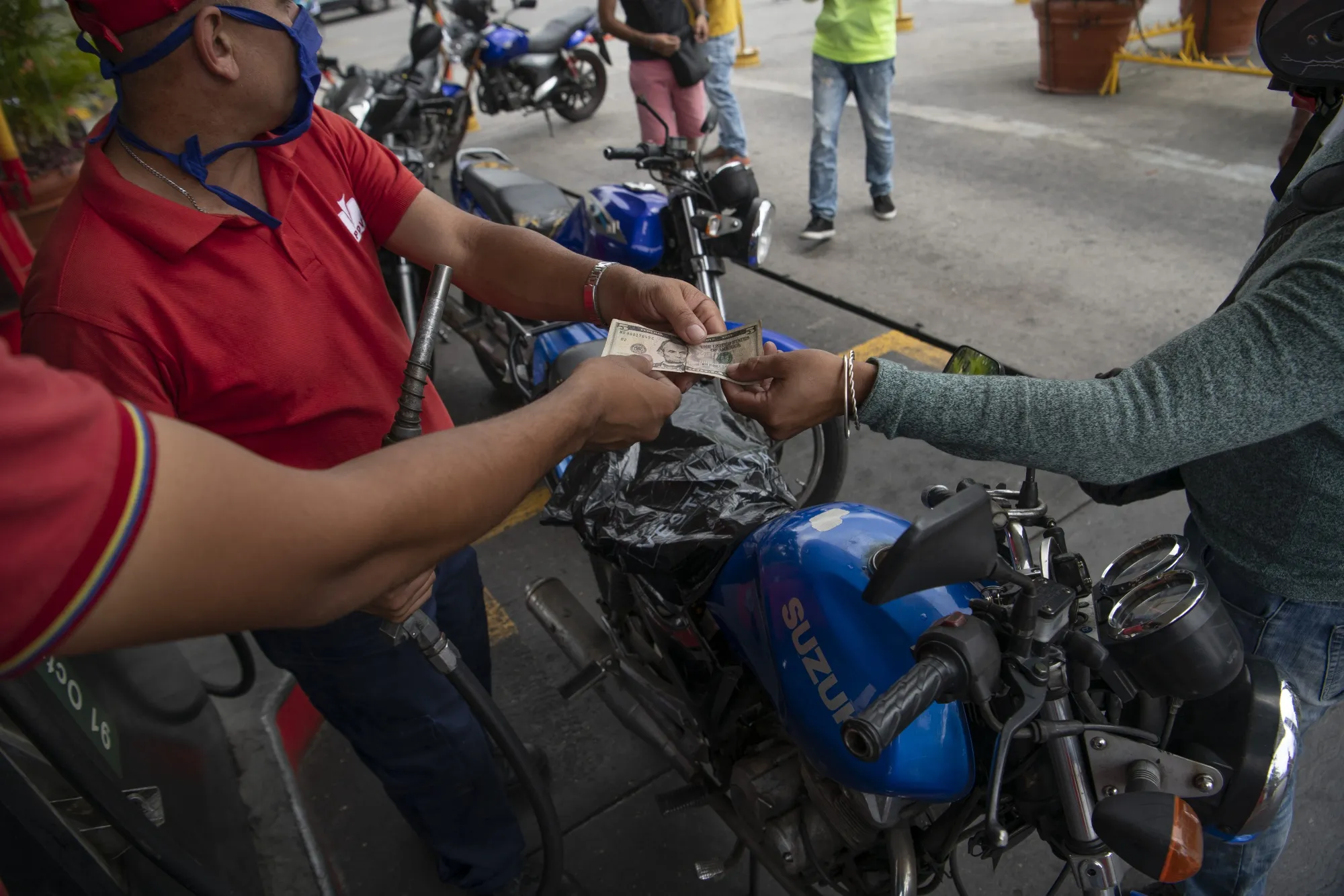A motorcyclist pays for gas in Caracas, Venezuela, June 1.
