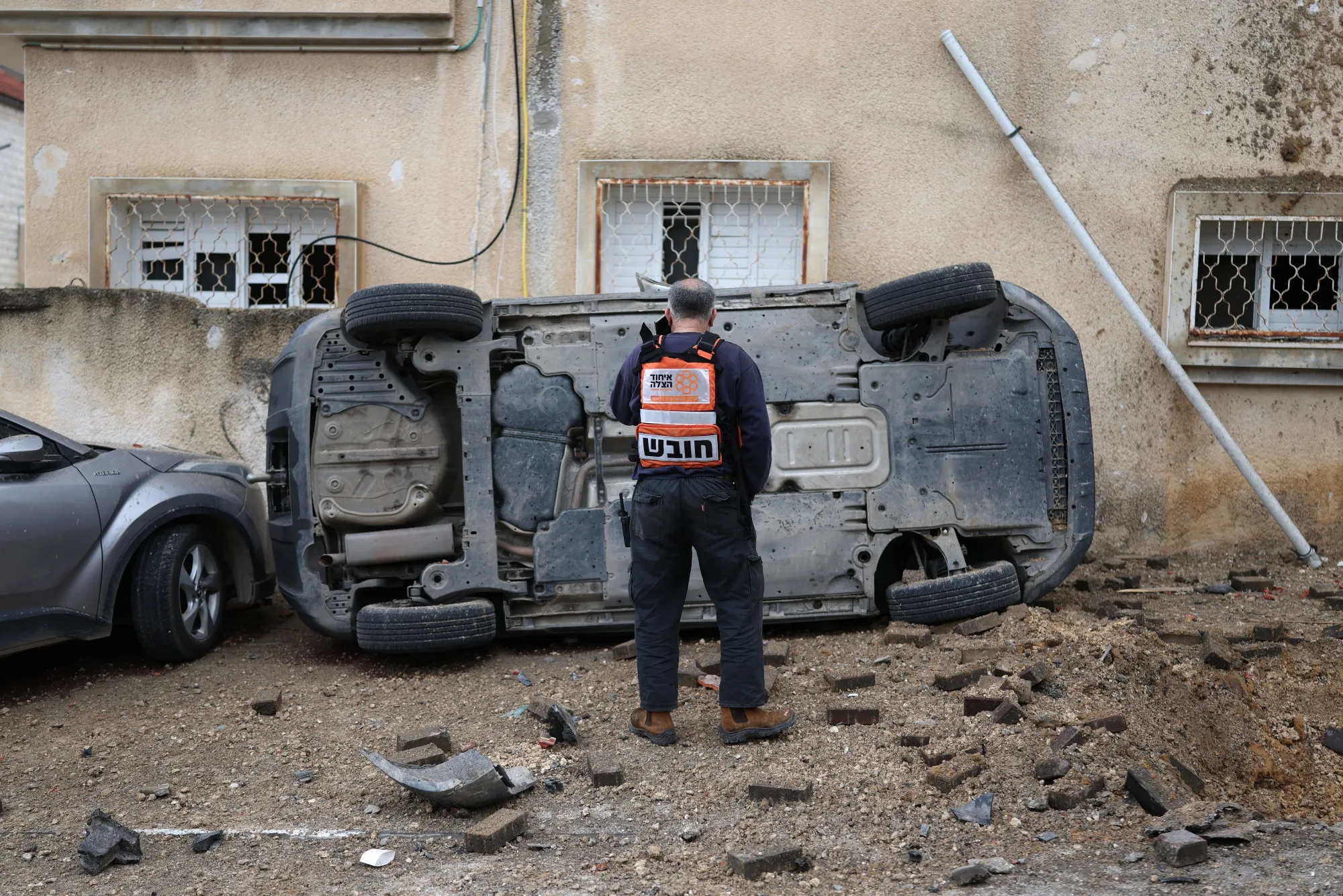 A man surveys the damage to a car following a strike in the Arab-Israeli city of Kfar Qassem,&nbsp;on March 26.