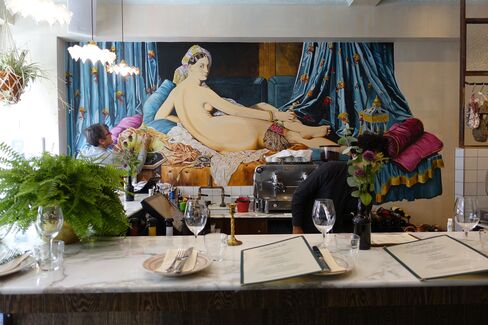 A painter puts the finishing touches to the mural at Blanchette on Brick Lane.