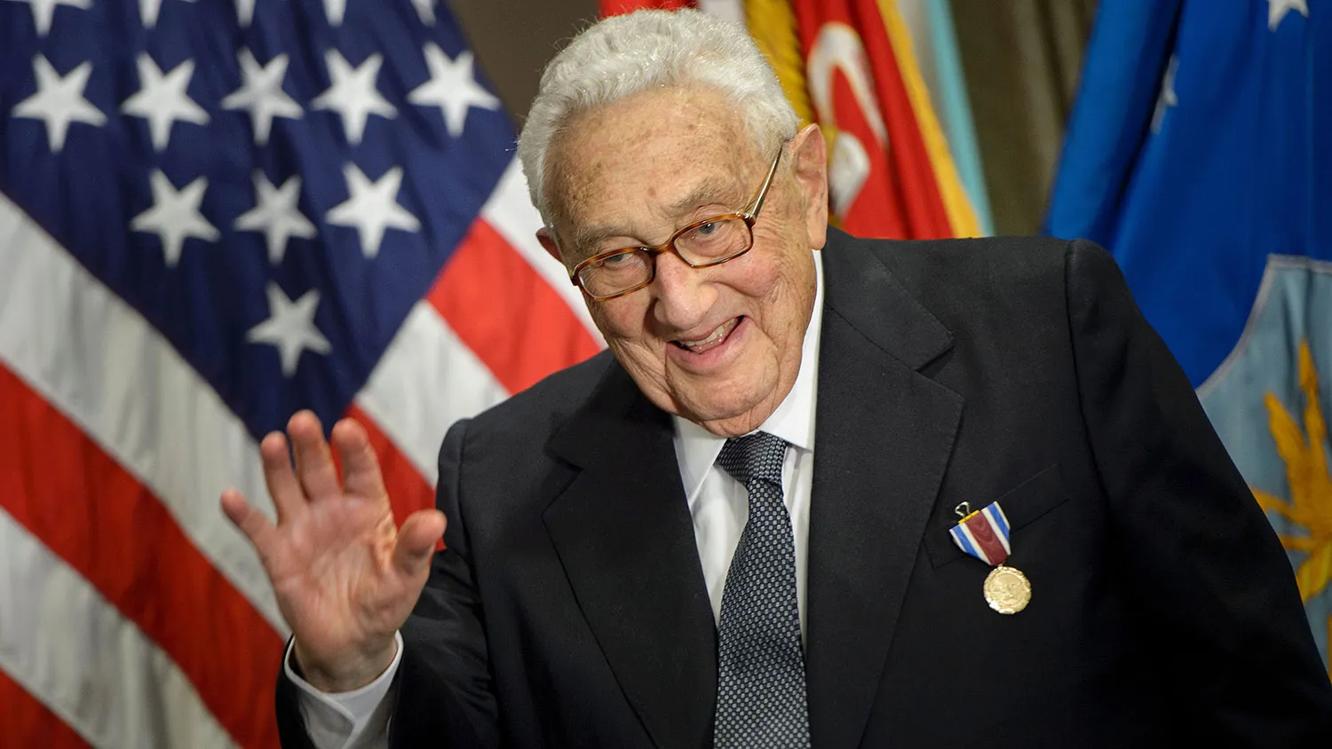 Former Secretary of State Henry Kissinger waves after receiving an award during a ceremony at the Pentagon on May 9, 2016, in Washington.
