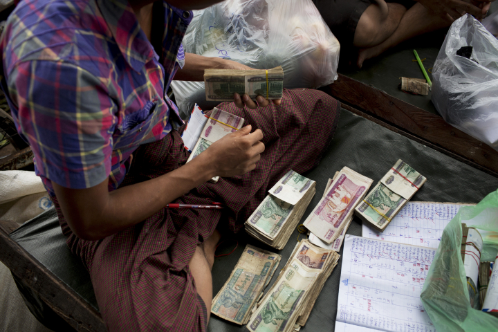 A man counts Myanmar kyat banknotes at a&nbsp;market in Yangon.