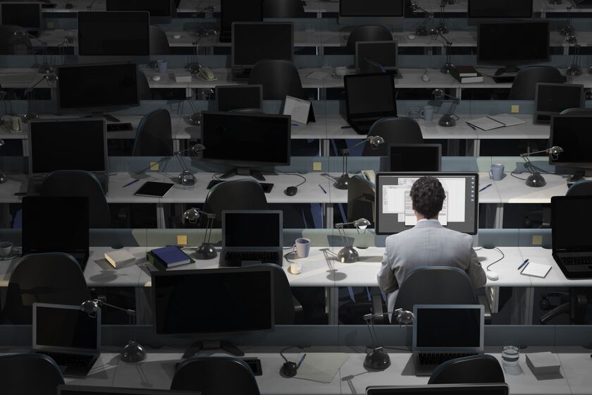 An office worker sits working in an empty office