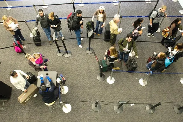 Travelers wait in line to go through security in the departure hall at San Francisco International Airport