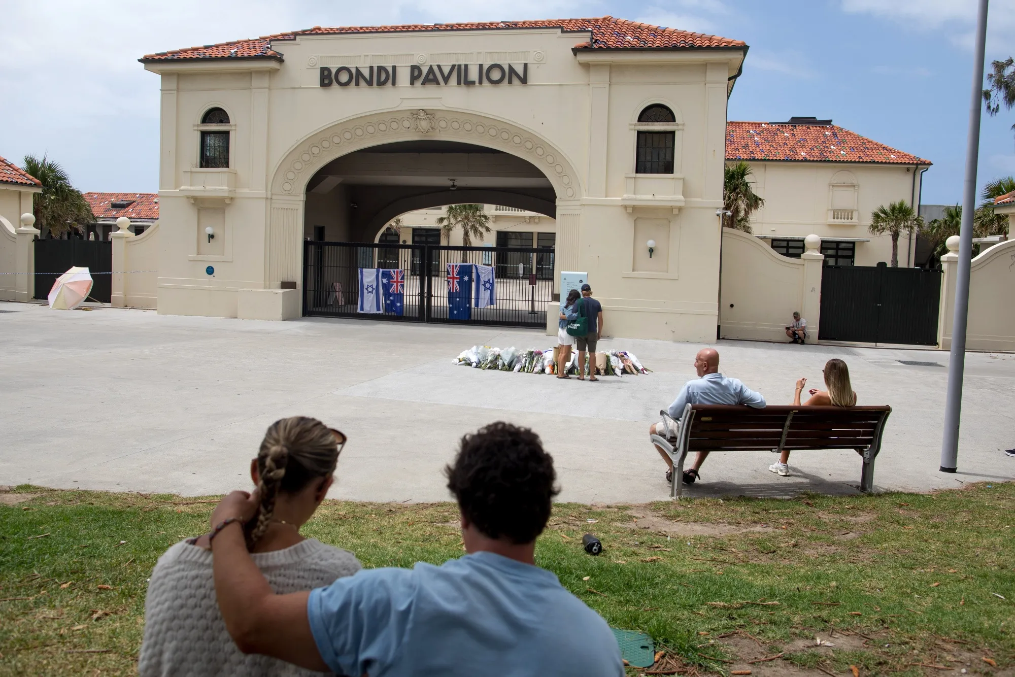 People gather in front of Bondi Pavilion, near the scene of the mass shooting at Bondi Beach.