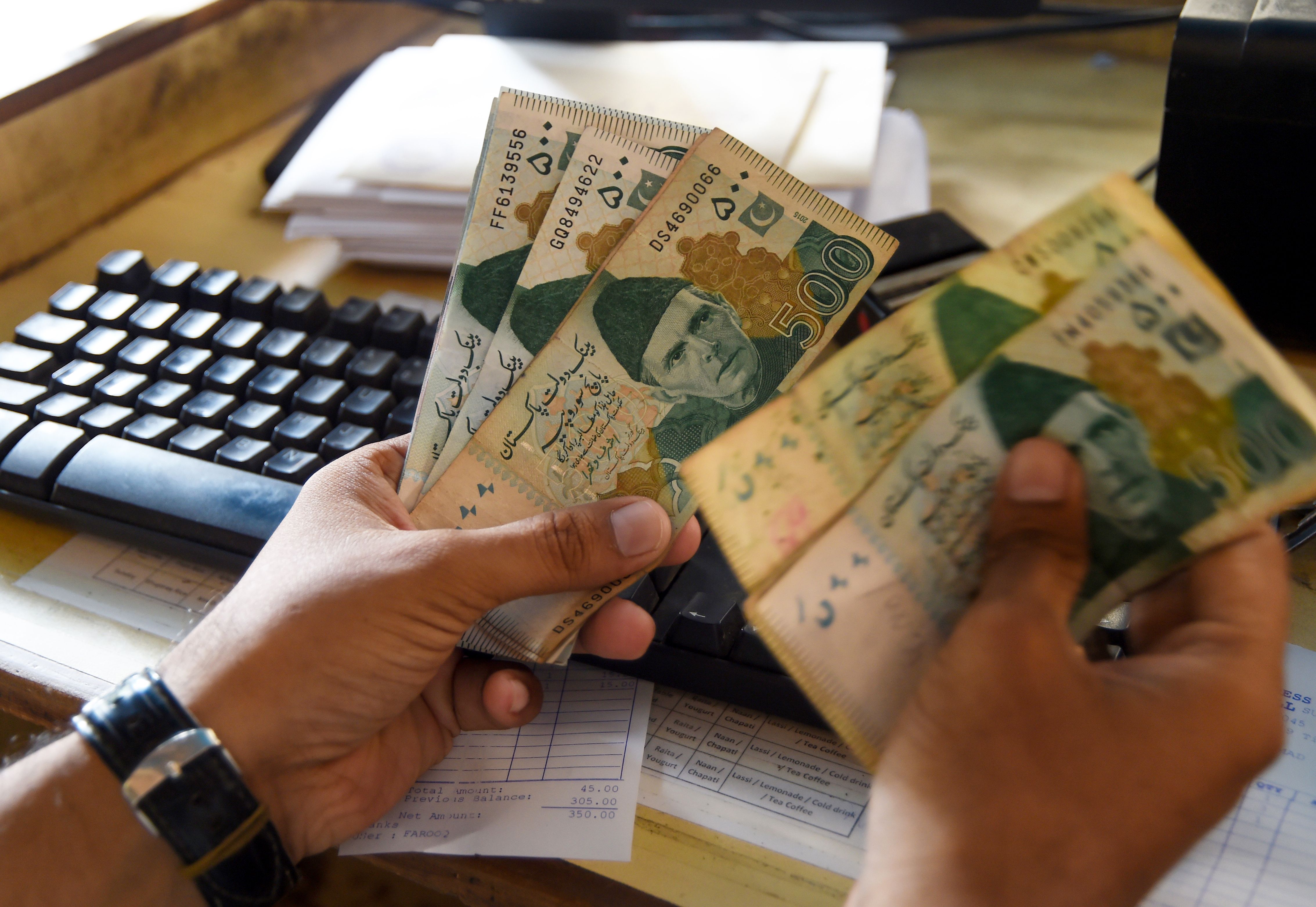 A person counts Pakistan&nbsp;rupees banknotes.&nbsp;