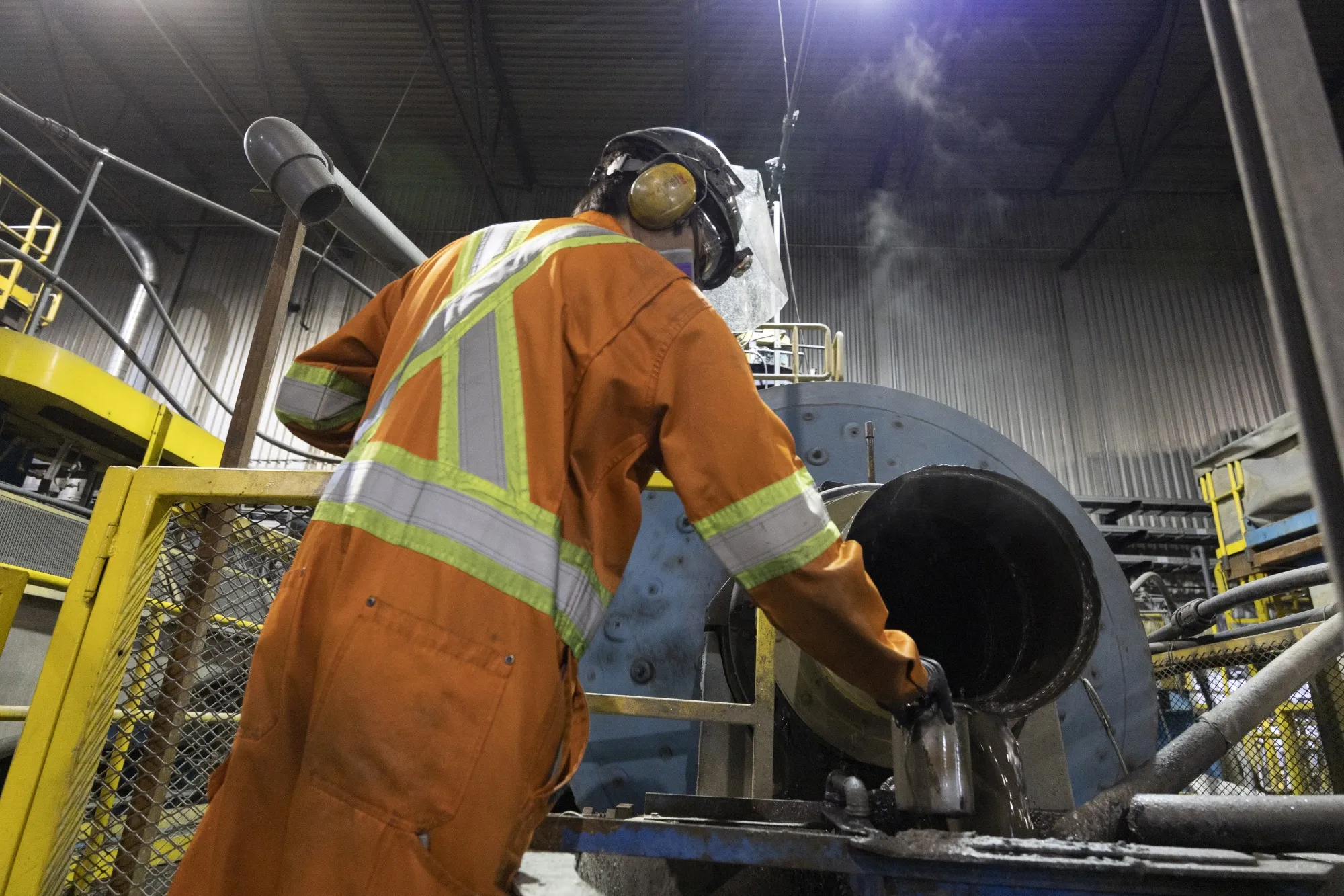 A worker takes a sample from the graphite concentrator at the Nouveau Monde Graphite facility in Saint-Michel-des-Saints, Quebec, in 2022.