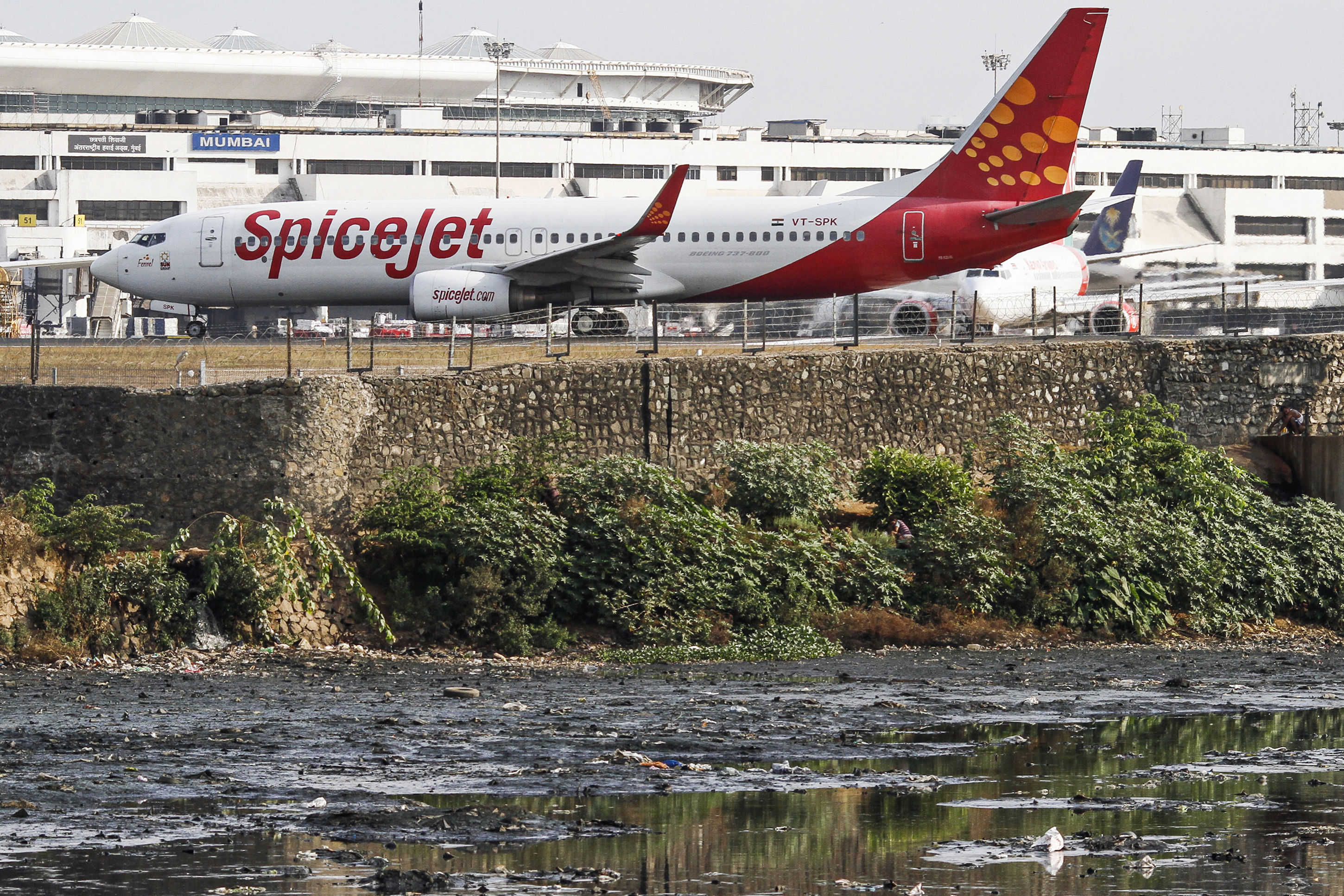 A SpiceJet Ltd. aircraft stands on the tarmac at Chhatrapati Shivaji International Airport in Mumbai, India.
