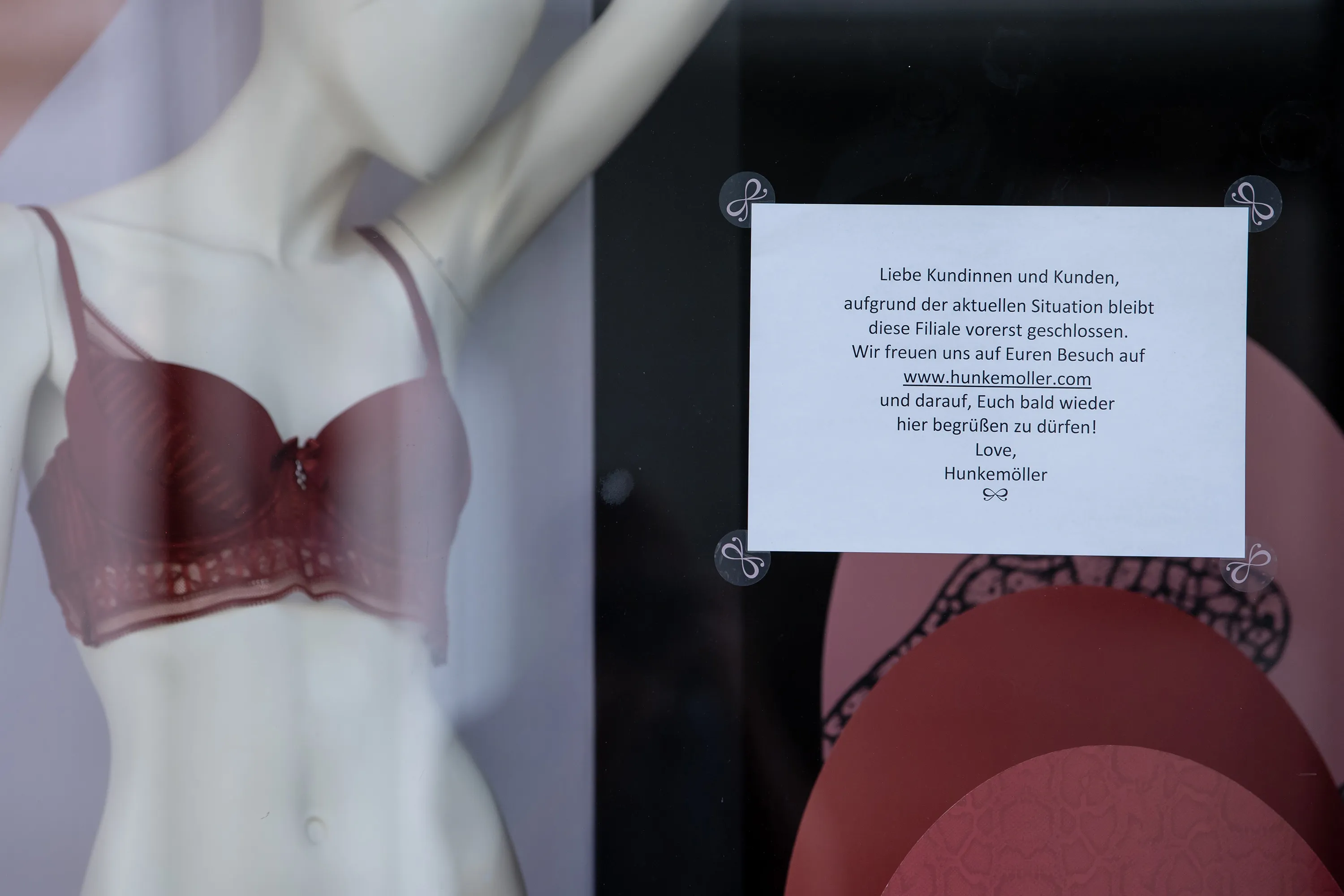 A notice in a window of a Hunkemoller store in Munich informs customers of temporary closure due to Covid-19.