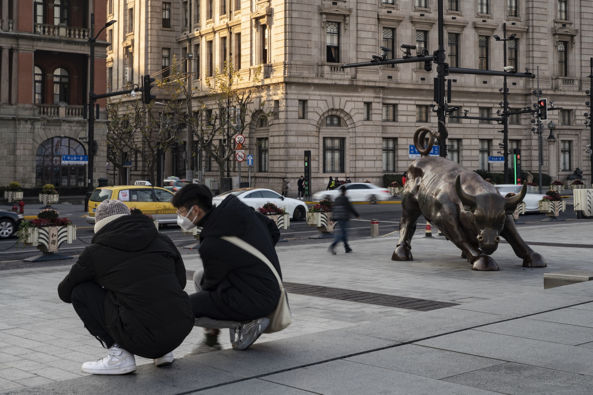 On December 21, two people kneeled near the Bund Bull statue in Shanghai.