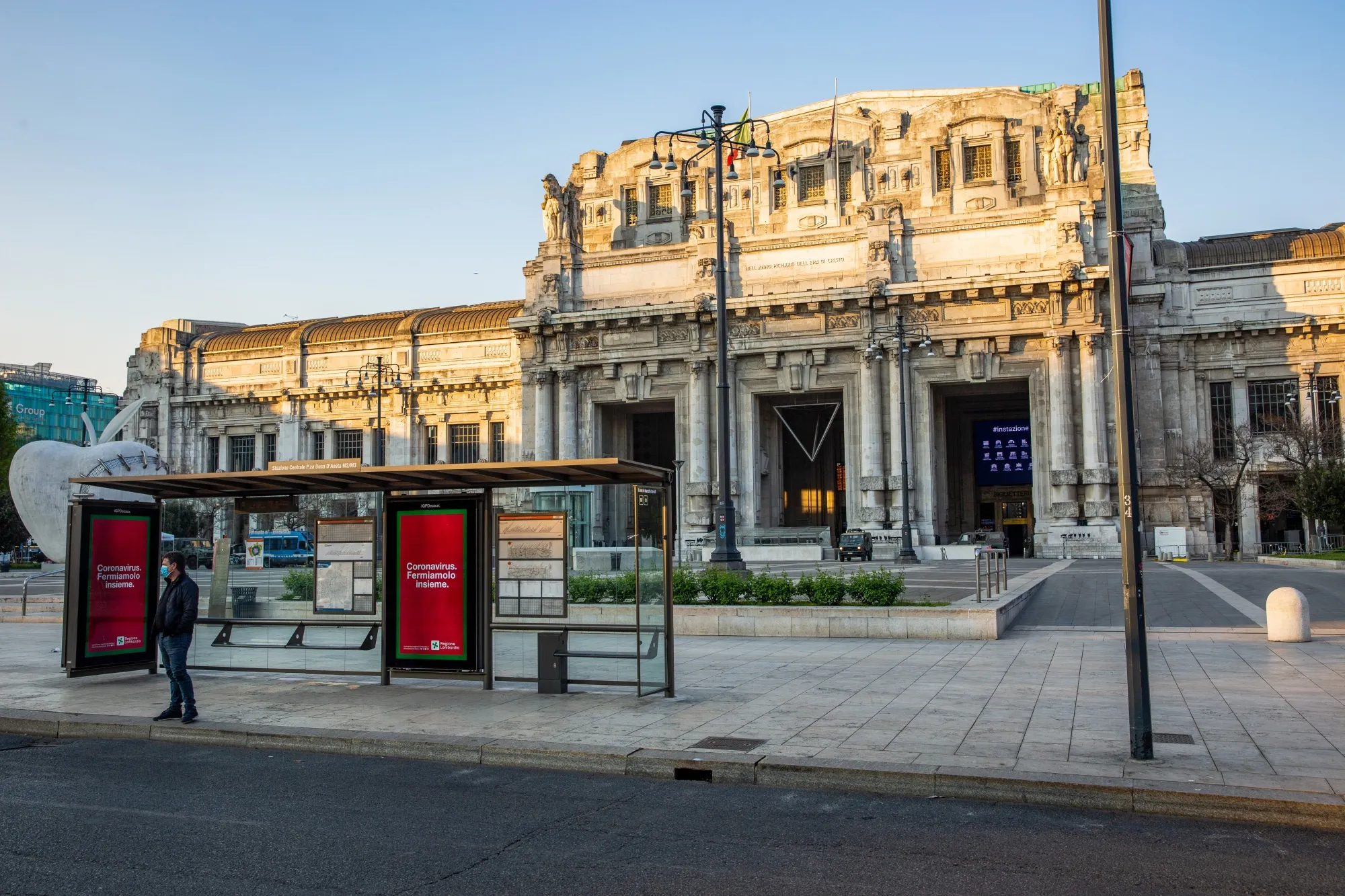A traveler waits at a bus stop near Milan Central Station on April 8.