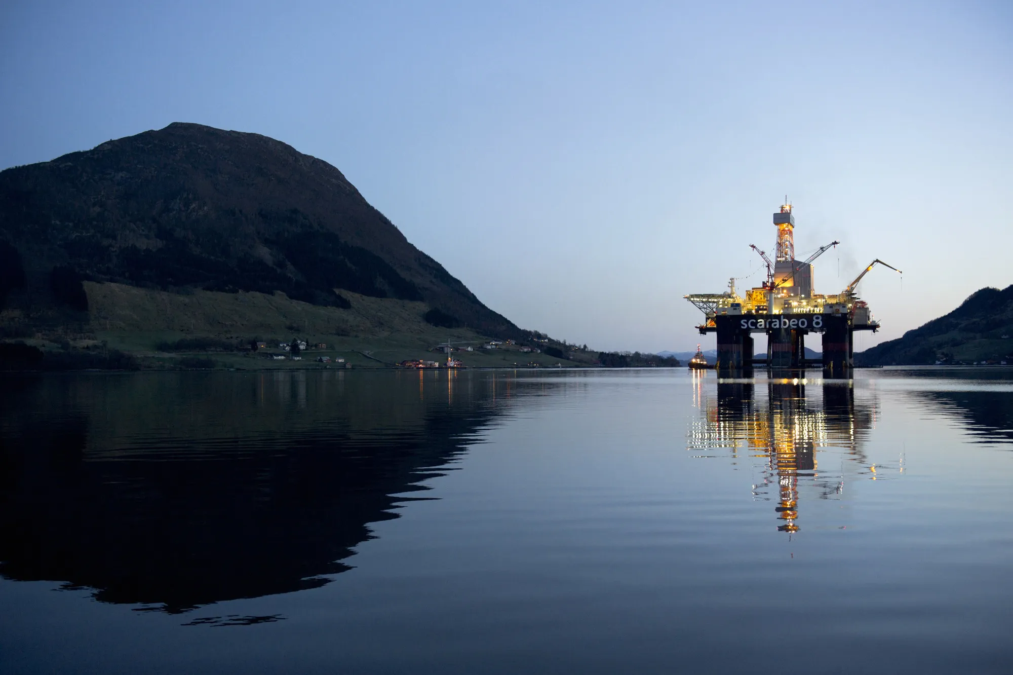 The Scarabeo 8 deepwater oil drilling rig, operated by ENI Norge AS, stands illuminated at night after being re-fitted at the Westcon AS yard in Olensvag, Norway.