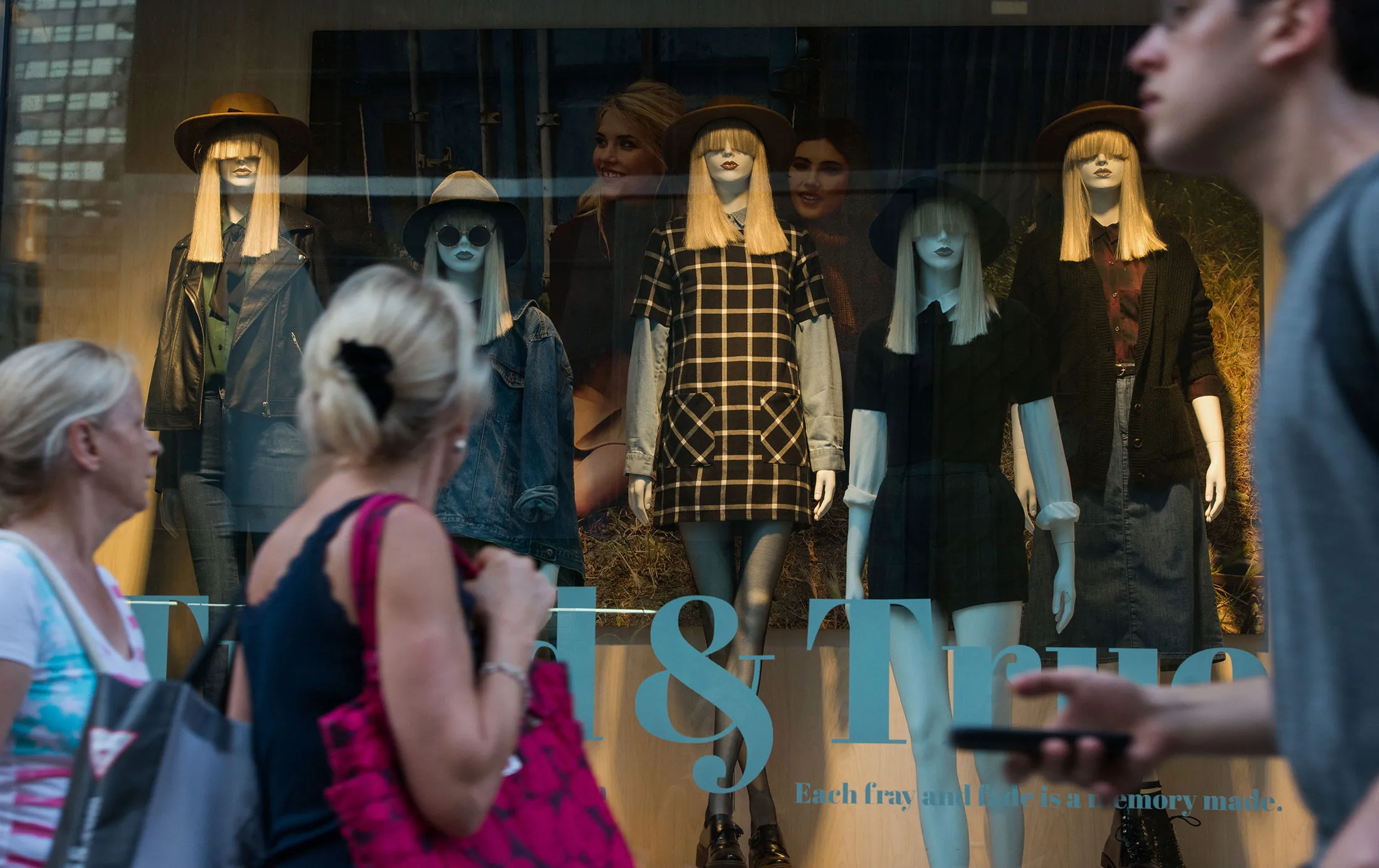 Pedestrians stroll by the fall window display at a Forever 21 store on 5th Avenue in New York, U.S., on Monday, Sept. 7, 2015.
