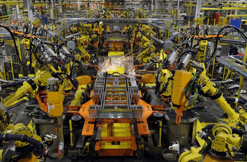 Robotic arms perform spot welds on the chassis of a van under assembly at a Ford assembly plant in Claycomo, Missouri. 