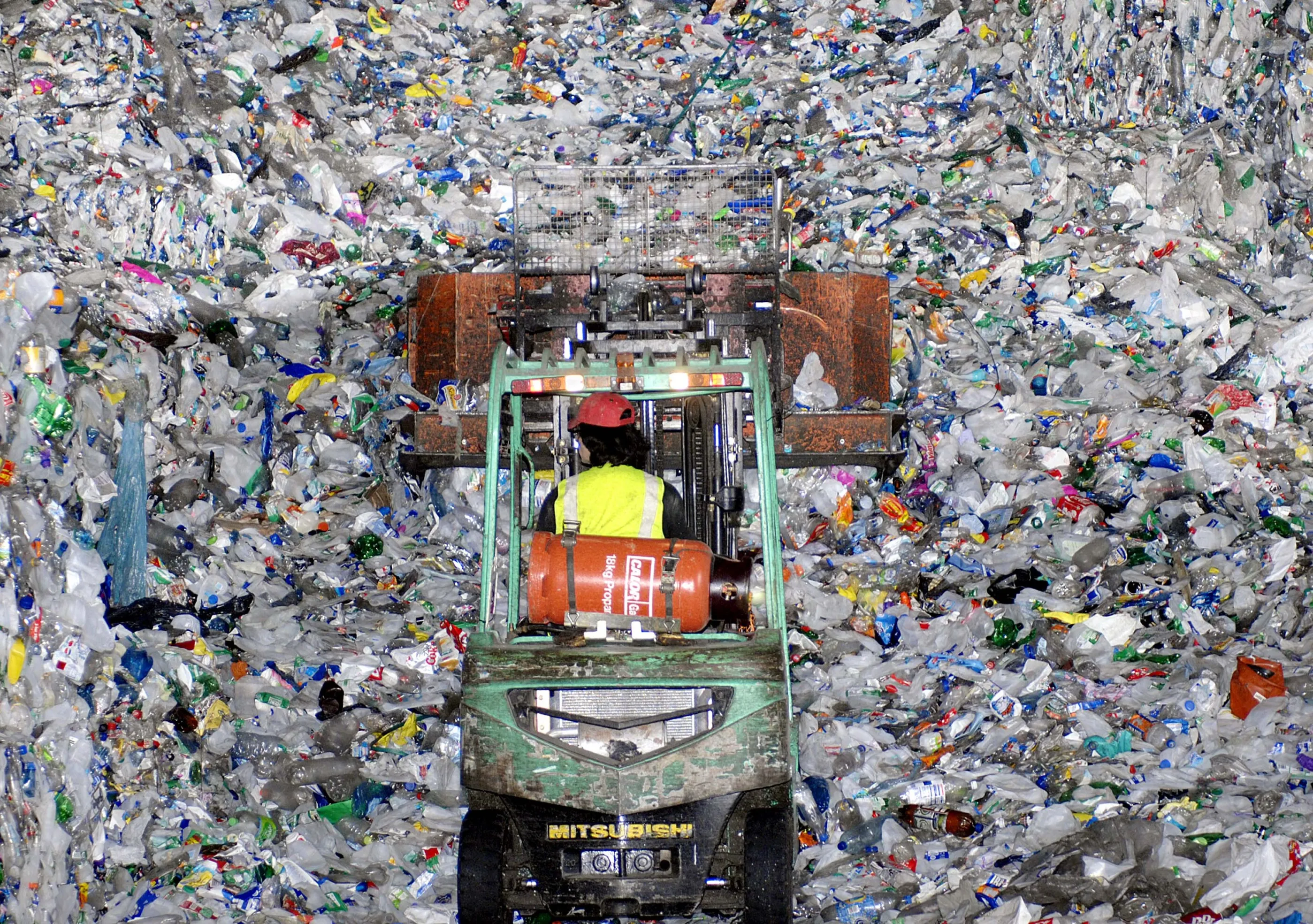 An employee uses a fork lift to move discarded plastic bottles ready for crushing and recycling at the Alternative Waste Solutions factory in the UK.&nbsp;