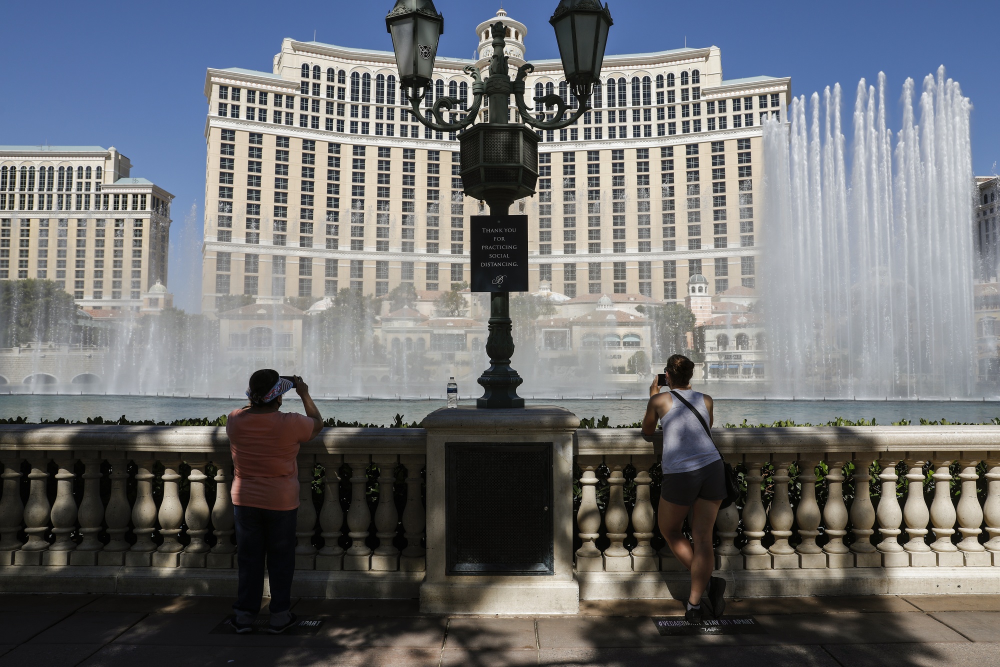 People watch the fountain show at the Bellagio Hotel and Casino before doors open to the public in Las Vegas, Nevada, U.S., on Thursday, June 4, 2020. All gaming venues in Nevada must follow strict protocols to account for Covid-19, including reduced capacity, more spacing on the casino floor and increased sanitation. Photographer: Joe Buglewicz/Bloomberg