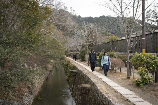 People walk along the 2-mile-long Philosopher’s Path next to a brook.