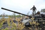 A Ukrainian serviceman stands on the turret of a destroyed Russian army tank not far from Kyiv on April 3, 2022.