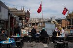 Diners at a terrace outside a port-side cafe in Istanbul, Turkey.