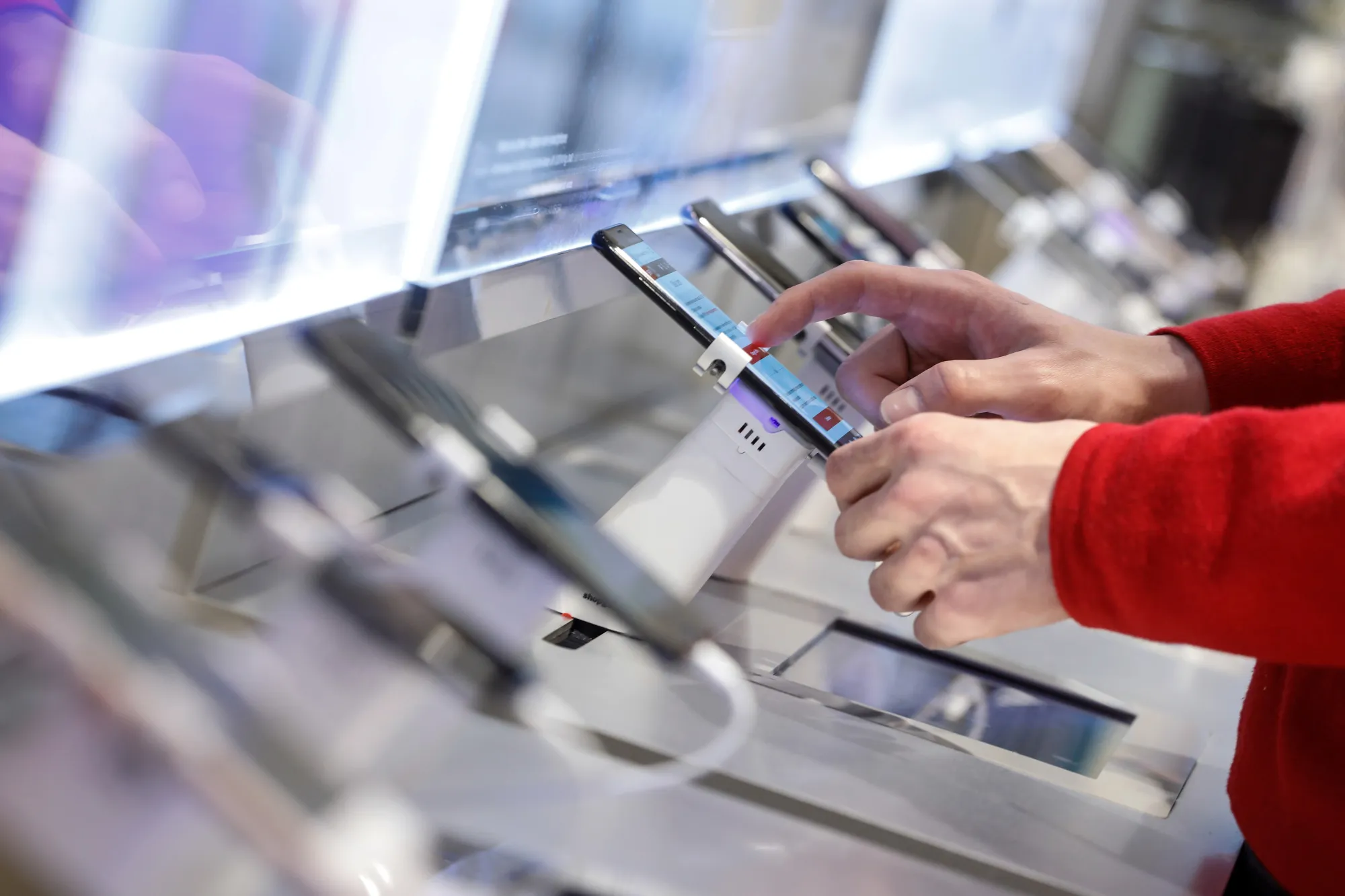 An employee arranges a smartphone display inside an SFR mobile phone store, operated by Altice NV, in Lille, France.