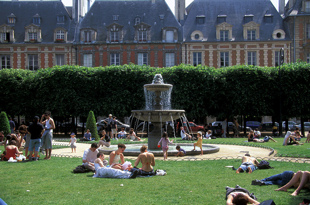 Los amigos se reúnen en el parque Place des Vosges de París.