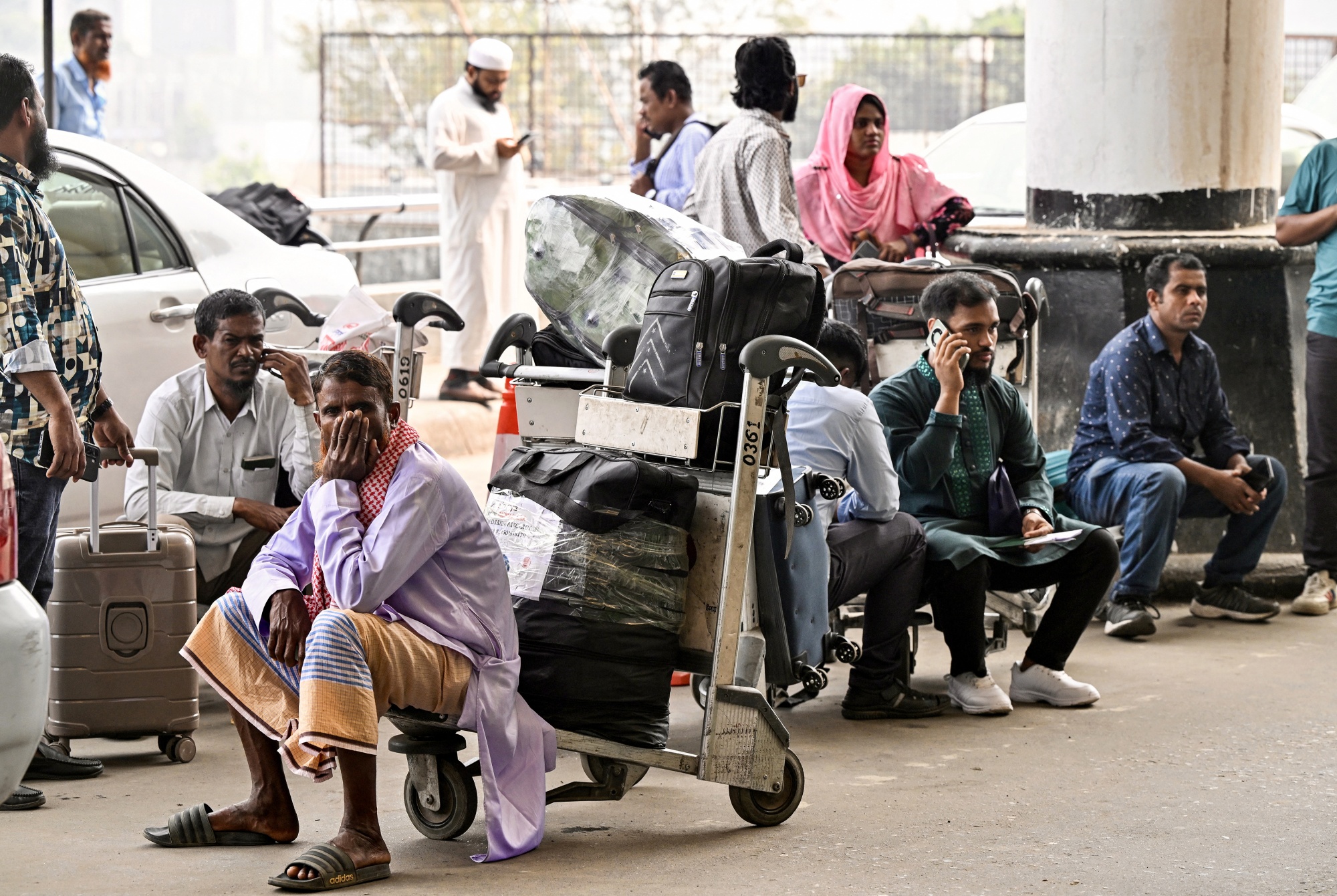 Stranded passengers wait with their luggage after carriers cancelled flights, outside the Hazrat Shahjalal International Airport in Dhaka on March 3. Photographer: Munir Uz Zaman/AFP/Getty Images