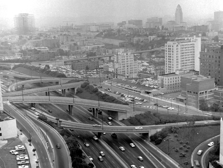 A complex of freeways and new construction sit among familiar landmarks and smog in Los Angeles in 1962.