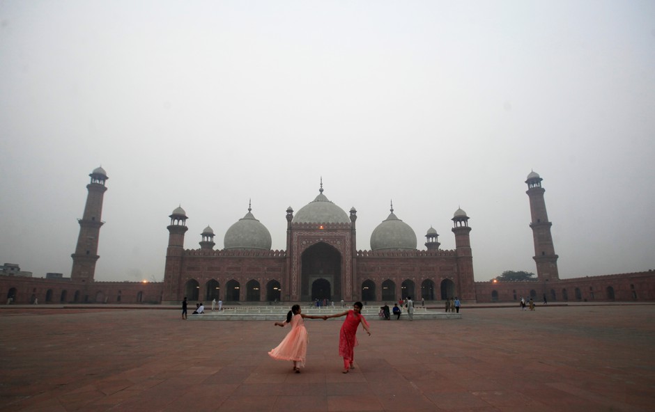 Two girls play outside a mosque in Lahore. 