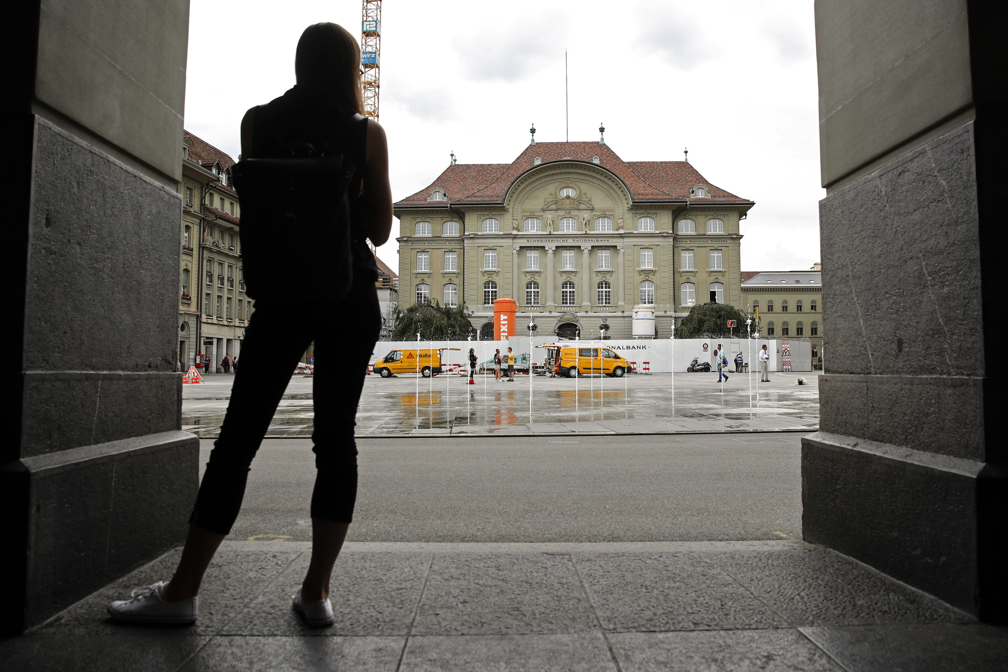 A pedestrian looks towards the Swiss National Bank (SNB) building in Bern.&nbsp;