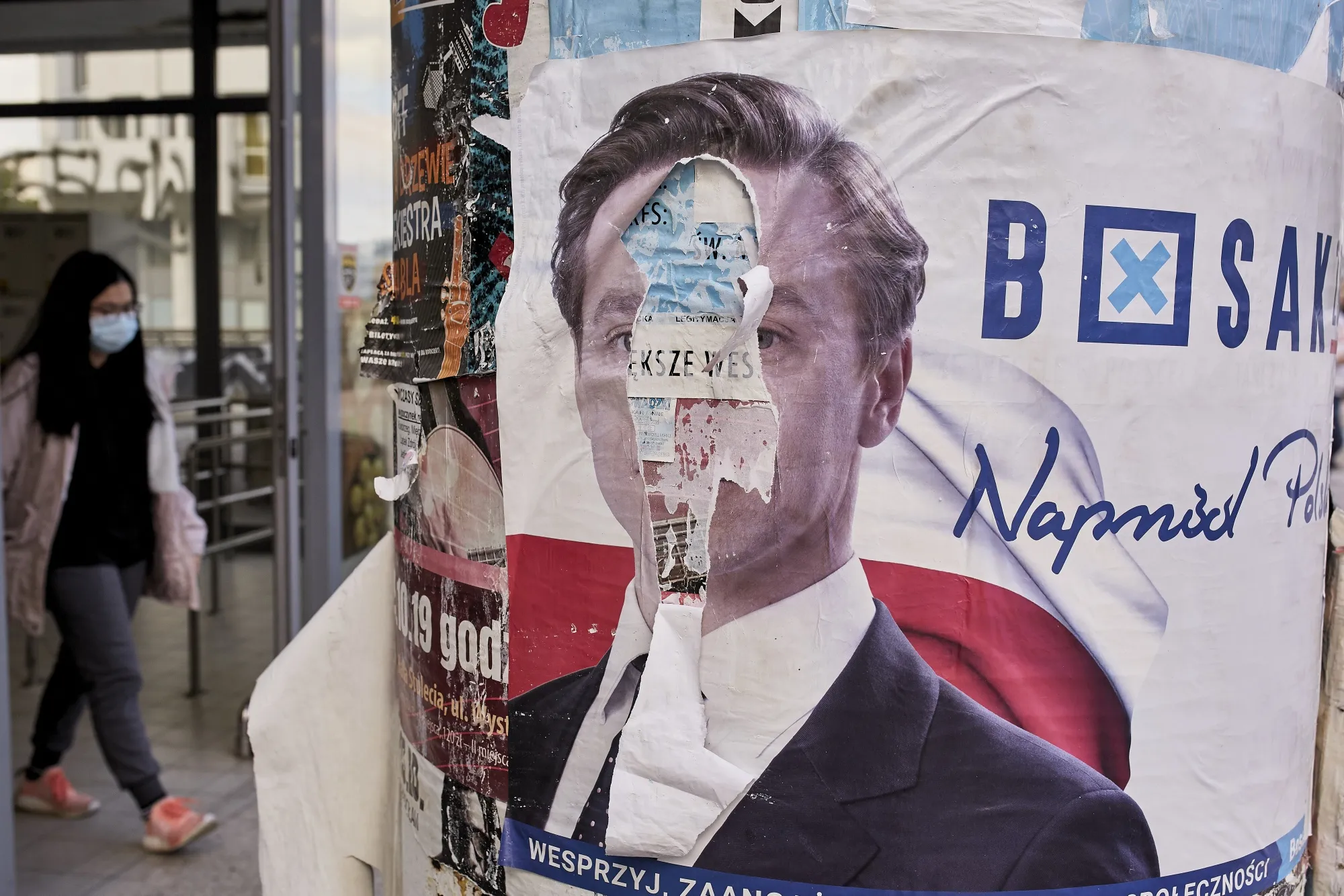 A presidential election campaign poster featuring Krzysztof Bosak, a Confederation Liberty and Independence party candidate, is displayed defaced on a post in Wroclaw, Poland.