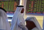 Traders sit below the stock market screens at the Dubai Financial Market&nbsp;