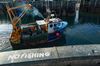 A 'No Fishing' sign sits on the quayside as a fishing boat heads out to sea from the harbour in Scarborough, U.K.