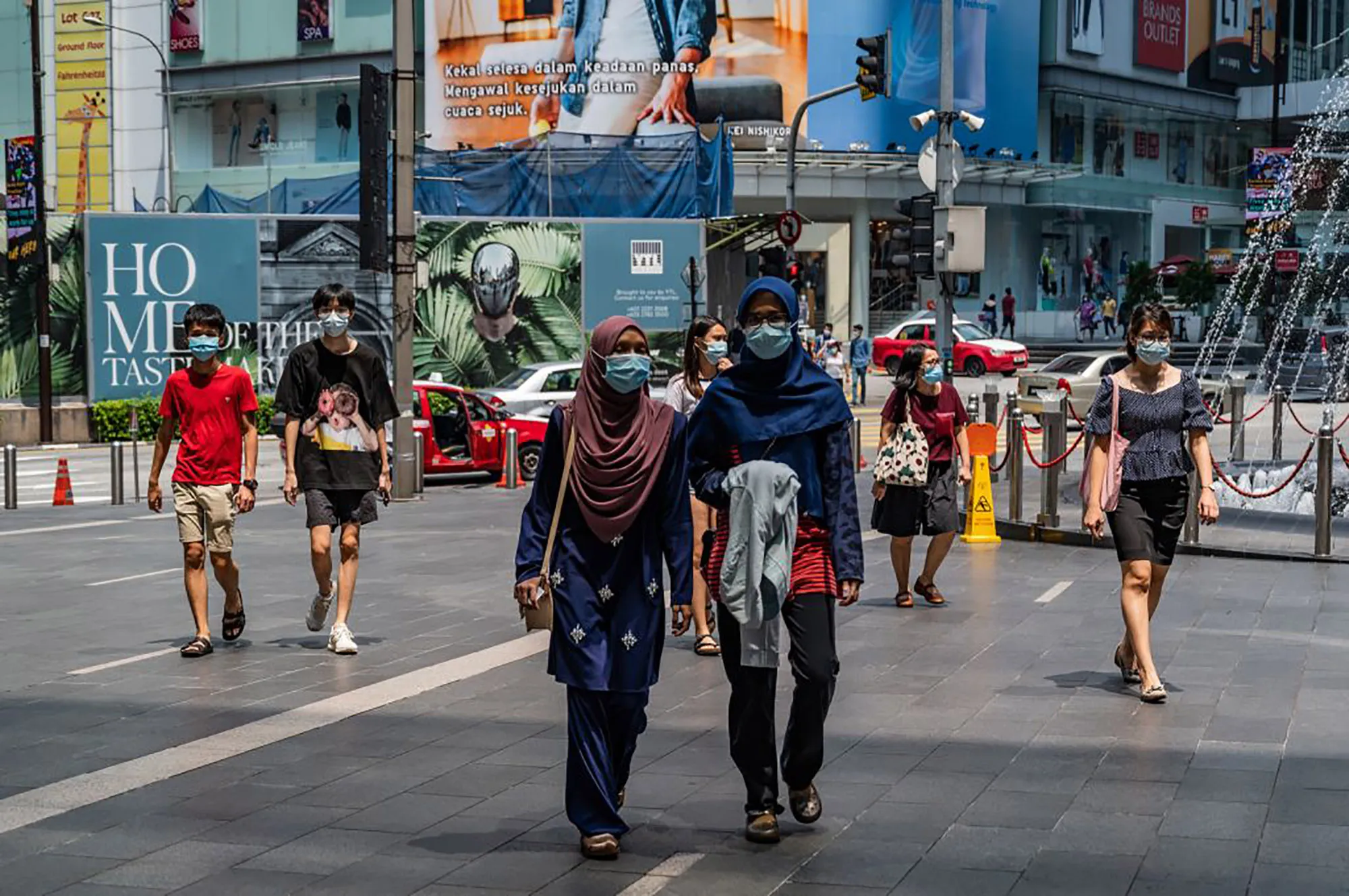 Shoppers walk outside a shopping mall in Kuala Lumpur.