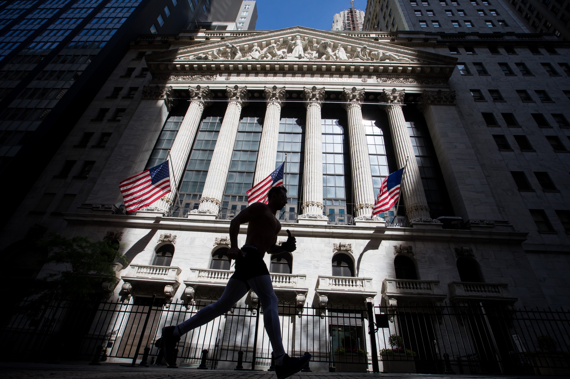 A jogger passes in front of the New York Stock Exchange in New York.