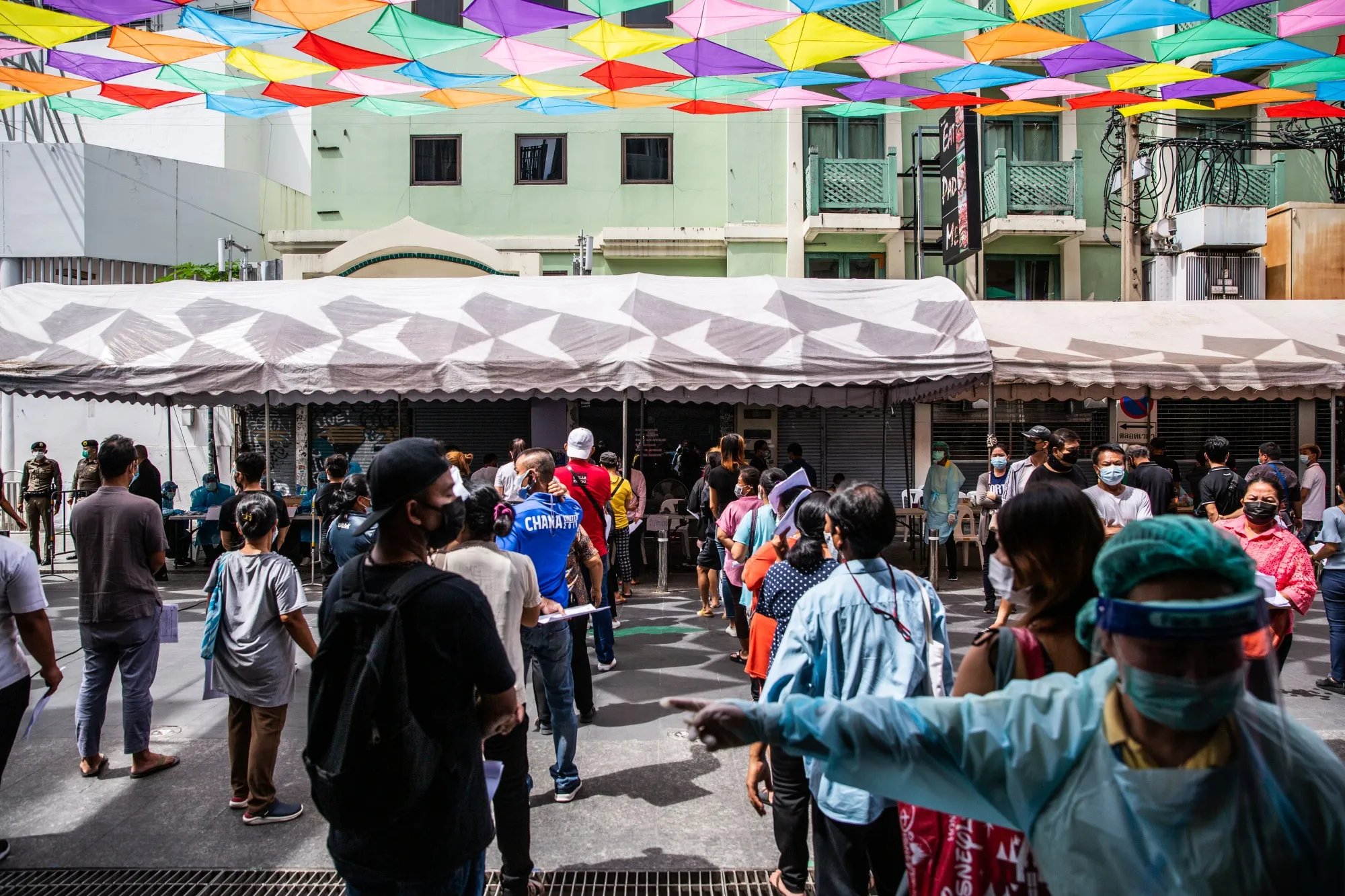 Healthcare workers direct people through waiting lines at a temporary Covid-19 testing site set up on Khaosan Road in Bangkok on April 19.