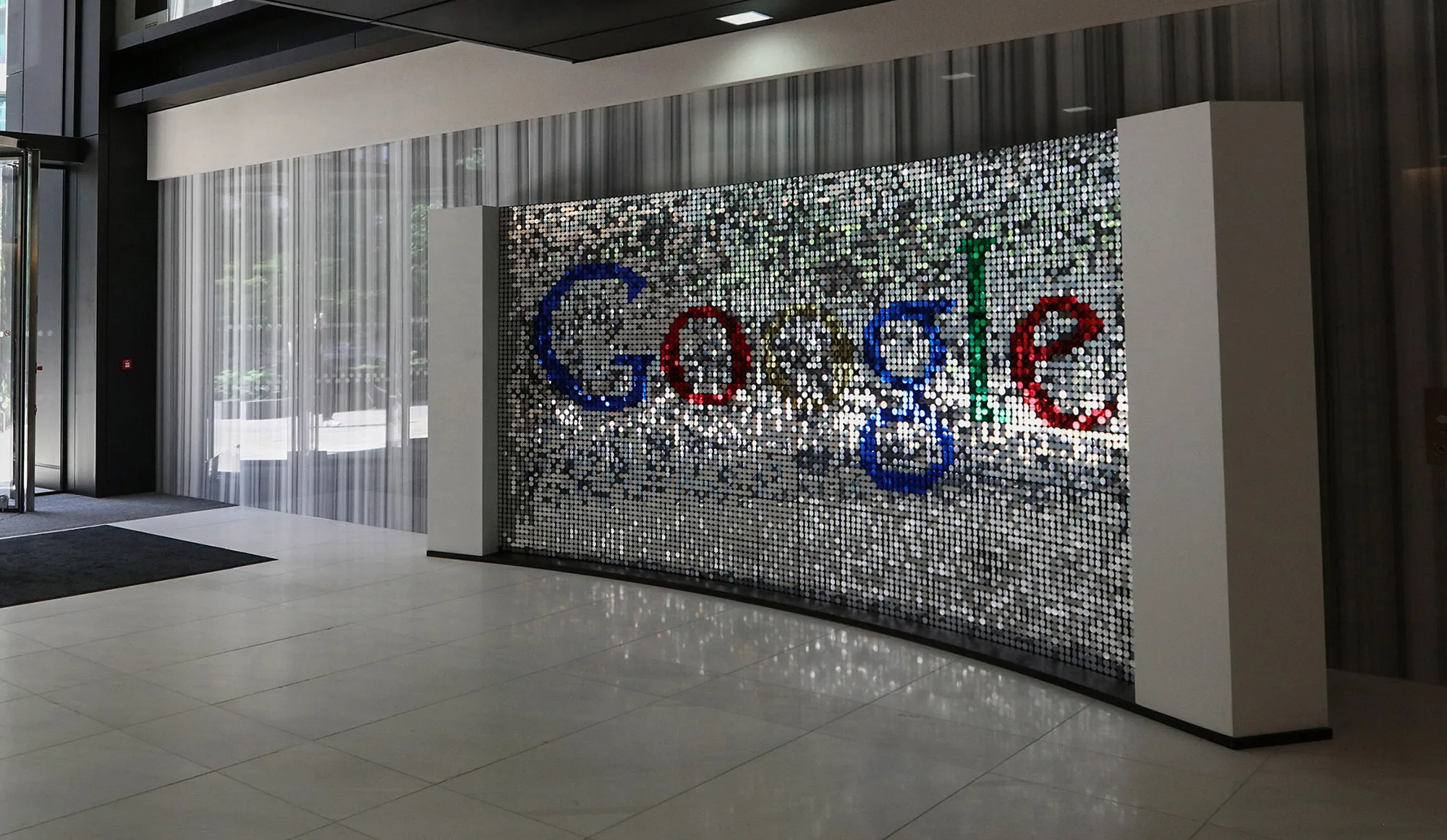 A visitor passes a sign featuring Google Inc.'s logo inside their U.K. headquarters at Six St Pan&nbsp; &nbsp; &nbsp;cras Square in London.