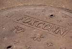A manhole cover imprinted with the Foxconn Technology Group logo.