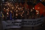 Protesters march with&nbsp;torches and a banner reading, 'let's raise salaries not the retirement age'&nbsp;in Perpignan, France on January 10.&nbsp;