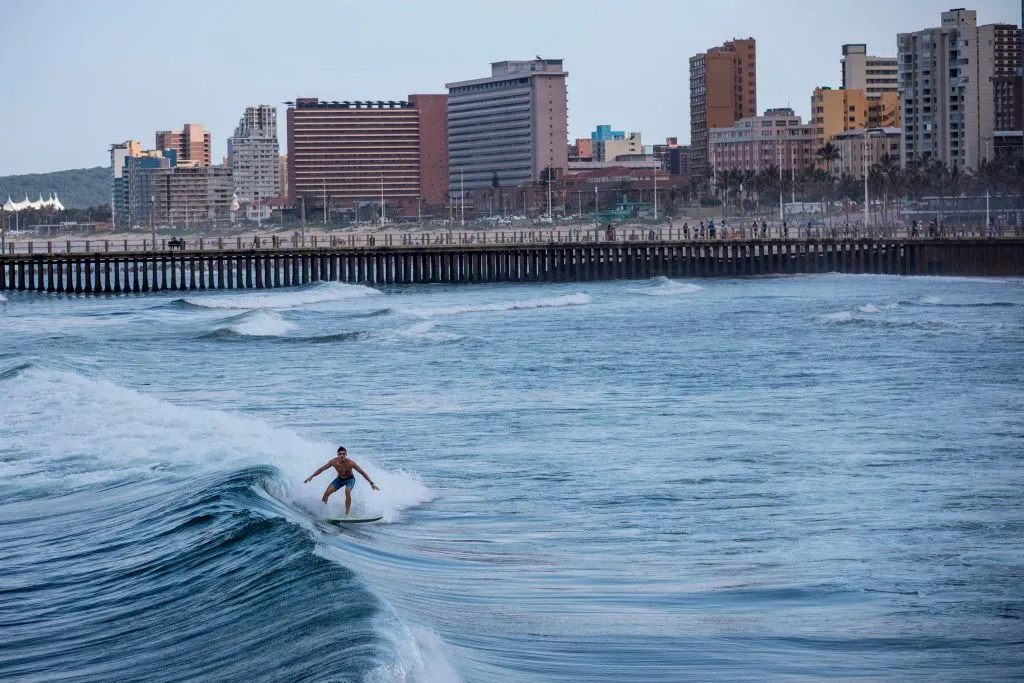 A surfer rides a wave at Durban's North Beach.
