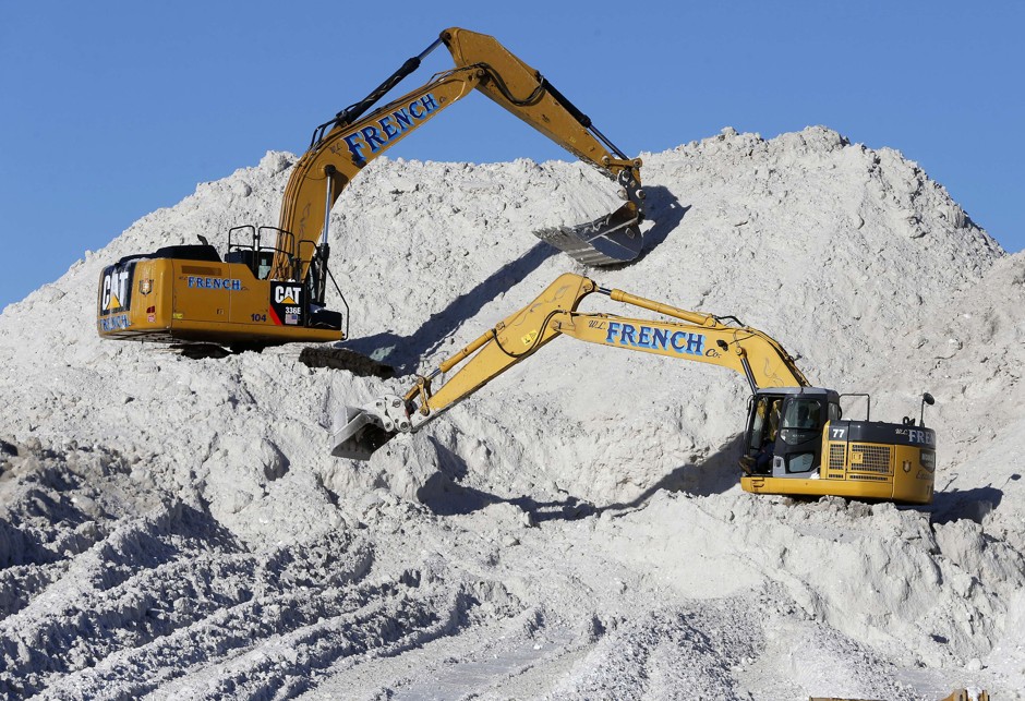 Heavy equipment works on a mound of snow that has been cleared from city streets at a &quot;snow farm&quot; in Boston, Monday, Feb. 16, 2015.