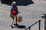 A shopper carries bags through a mall in Victoria, British Columbia on July 26.