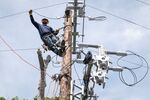 A Pacific Gas &amp; Electric Co. worker moves a wire into place while installing a bypass switch in Yountville, California&nbsp;in April 2020.&nbsp;