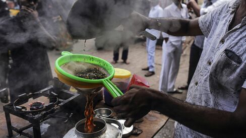 A vendor pours chai through a sieve at a roadside stall in Mumbai.