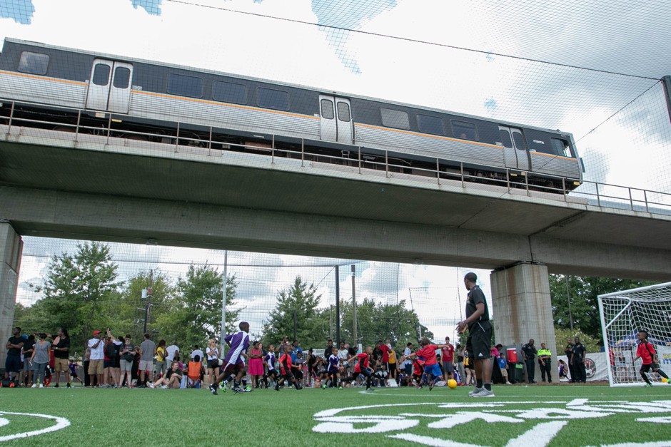 People play soccer on a new field below train tracks at Atlanta's West End station.